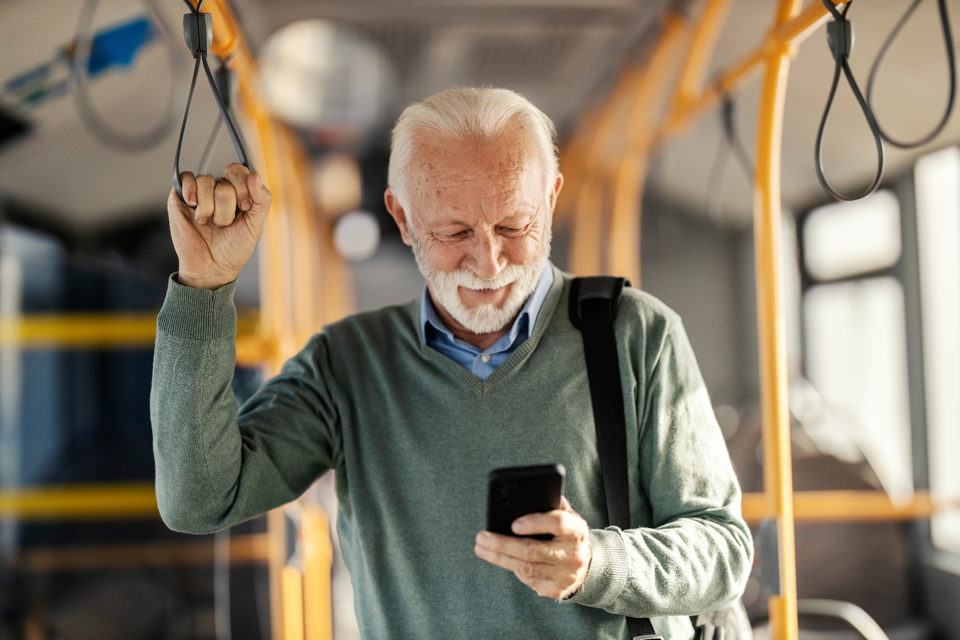 Older rider on a phone call inside a city bus